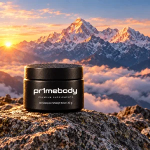 Himalayan shilajit resin jar from pr1mebody standing on a weathered granite boulder with snow-capped Himalayan peaks glowing in golden-pink sunrise light behind it